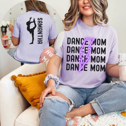 Trendy Comfort Colors Shirt with Dance Mom repeated with a purple lightning bolt in the middle. On the back of the shirt is a dancer with a customizable name.